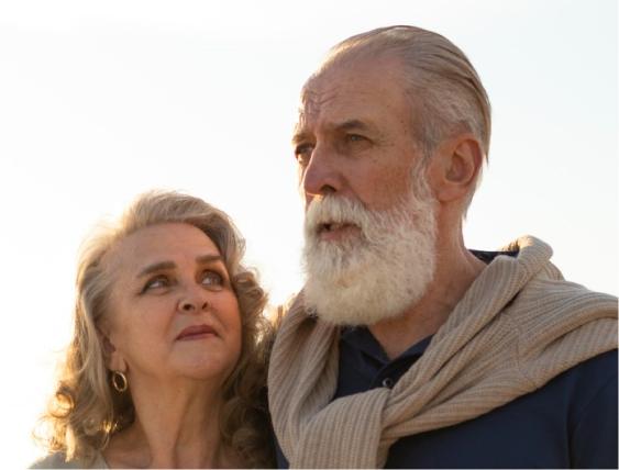 Elderly couple strolls at sunset, symbolizing mesothelioma compensation security.